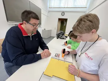 Schulleiter und Azubis mit dem neuen Lernstift