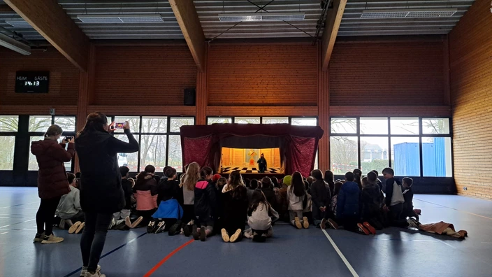 Fasziniert hören und sehen die Kinder beim Marionettentheater zu
