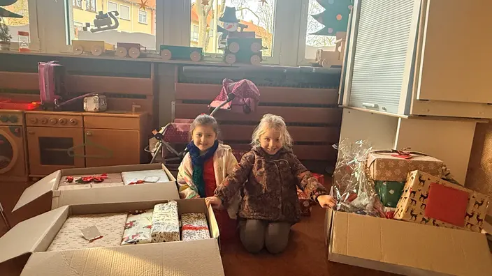 Kinder zwischen den Geschenkekisten