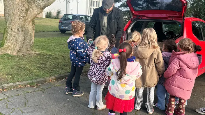 Kinder bringen die Geschenke ins Auto