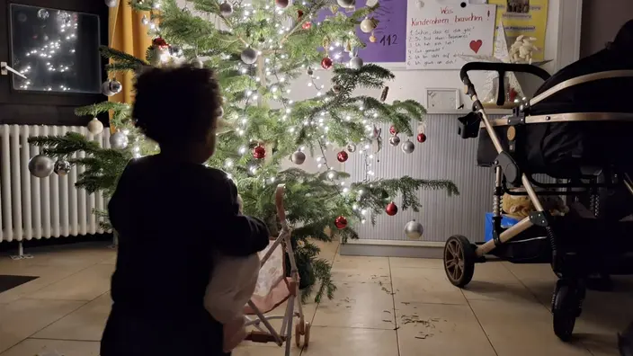 Kind bestaunt den Weihnachtsbaum