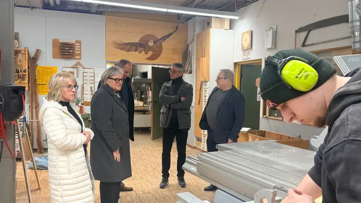 Besucher besuchen die Holzwerkstatt