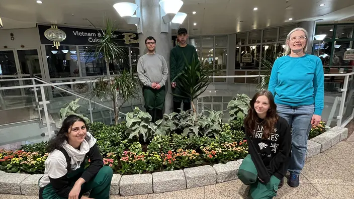 Azubis und Ausbilderin vor dem frisch angelegten Beet