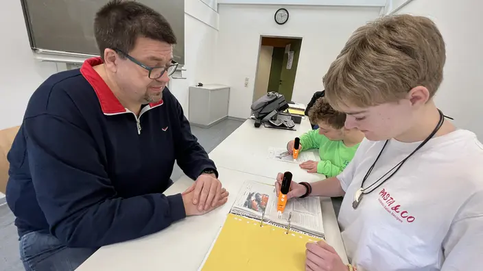 Schulleiter und Azubis mit dem neuen Lernstift