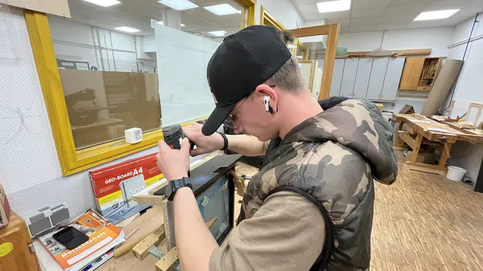 Azubi arbeitet in der Holzwerkstatt