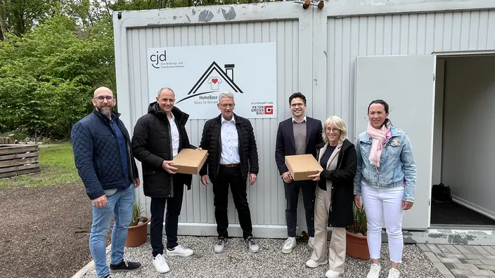Spender Peter Gross und CJD Geschäftsführung vor dem Store