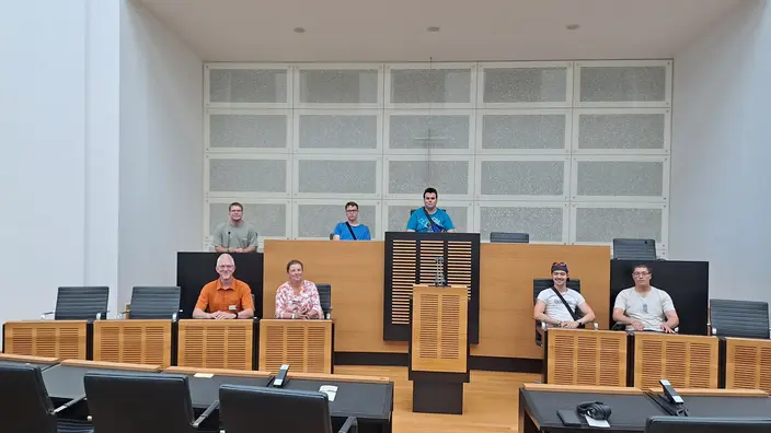 Jugendliche sitzen auf den Stühlen der Politiker im Landtag